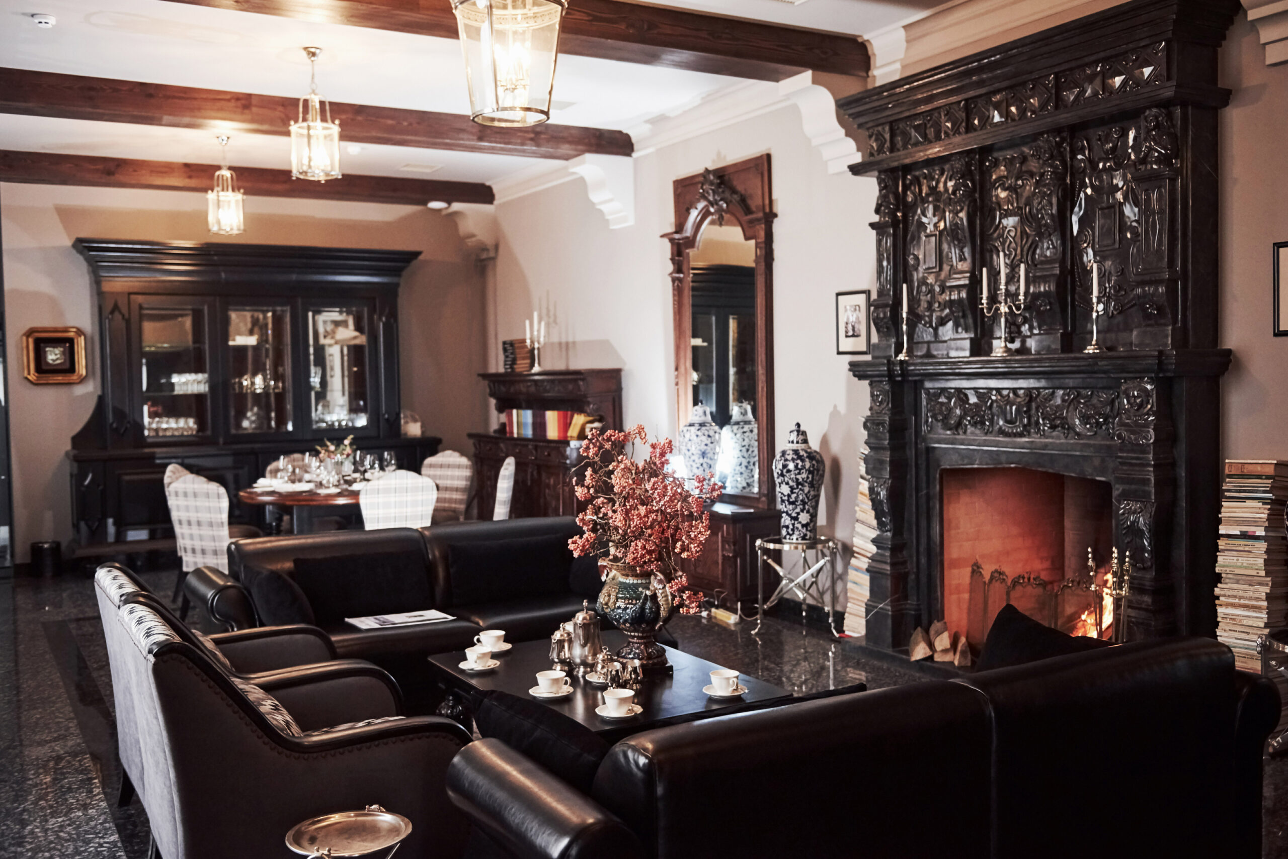 Flower, cups, tables and couches. Interior of luxury restaurant in vintage aristocratic style with beautiful fireplace